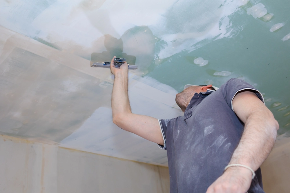 Gładzie – pracownik nakłada i wyrównuje masę na sufit